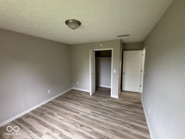 724 Iroquois St, Anderson, IN 46012 - unfurnished bedroom featuring wood finished floors, baseboards, a closet, and a textured ceiling
