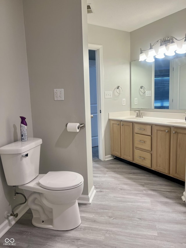 7532 Perilla Ct, Indianapolis, IN 46237 - full bathroom with wood finished floors, baseboards, toilet, and double vanity
