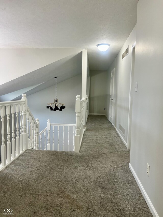 7532 Perilla Ct, Indianapolis, IN 46237 - corridor with carpet floors, an upstairs landing, a textured ceiling, a chandelier, and baseboards
