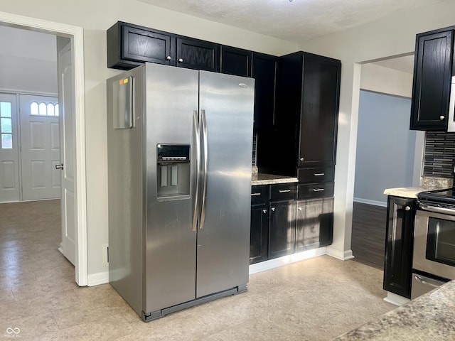 7532 Perilla Ct, Indianapolis, IN 46237 - kitchen with stainless steel appliances, dark cabinetry, baseboards, and light stone countertops