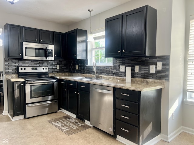 7532 Perilla Ct, Indianapolis, IN 46237 - kitchen with stainless steel appliances, a sink, dark cabinetry, and tasteful backsplash