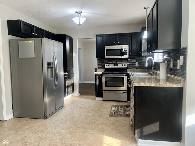 7532 Perilla Ct, Indianapolis, IN 46237 - kitchen featuring stainless steel appliances, a sink, dark cabinets, light floors, and decorative backsplash