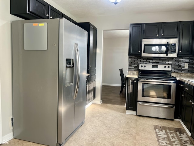 7532 Perilla Ct, Indianapolis, IN 46237 - kitchen with appliances with stainless steel finishes, dark cabinets, backsplash, and baseboards