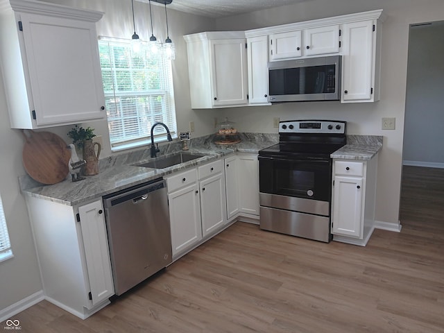 18851 Wimbley Way, Noblesville, IN 46060 - kitchen featuring stainless steel appliances, light wood-style flooring, white cabinets, light stone countertops, and pendant lighting