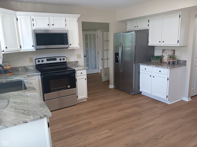 18851 Wimbley Way, Noblesville, IN 46060 - kitchen featuring appliances with stainless steel finishes, light wood-style floors, white cabinets, light stone countertops, and french doors