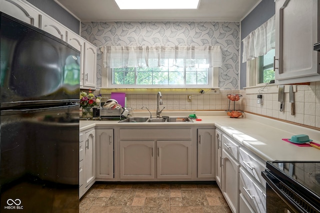 307 E 5th St, Sheridan, IN 46069 - kitchen featuring black appliances, a sink, healthy amount of natural light, and light stone finish flooring