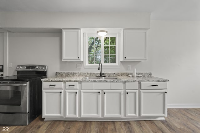 1948 Bloyd Ave, Indianapolis, IN 46218 - kitchen featuring stainless steel range with electric stovetop, white cabinets, light stone countertops, and dark wood-type flooring