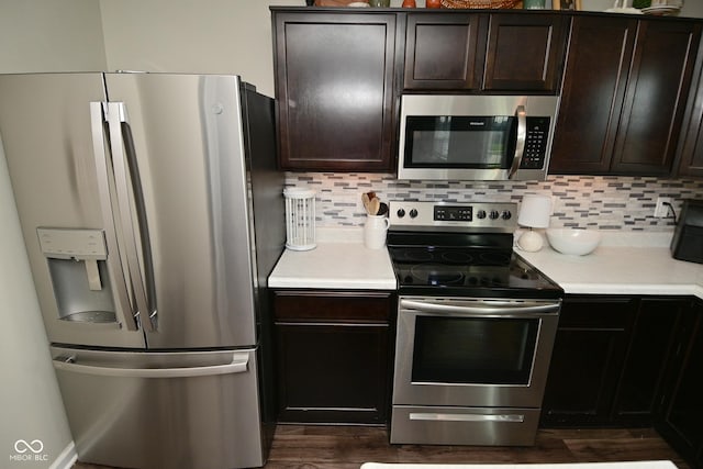 680 Albermarle Dr, Pittsboro, IN 46167 - kitchen with appliances with stainless steel finishes, decorative backsplash, light countertops, dark wood-style flooring, and dark brown cabinetry