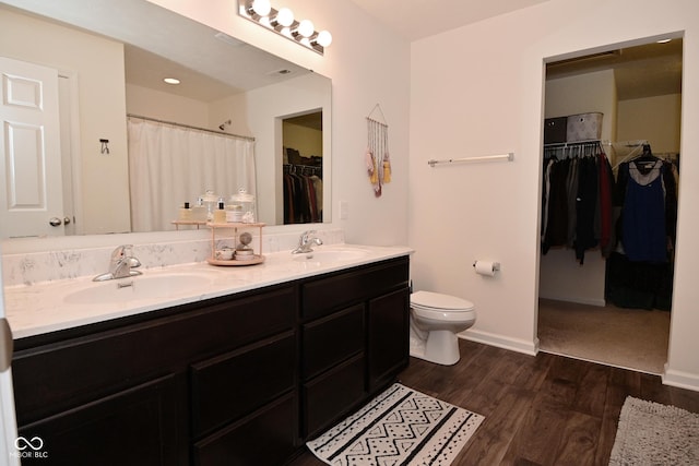 680 Albermarle Dr, Pittsboro, IN 46167 - full bathroom featuring double vanity, toilet, wood finished floors, a spacious closet, and baseboards