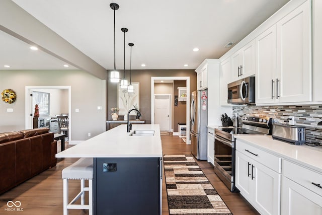 1295 Maclaren Ct, Franklin, IN 46131 - kitchen with appliances with stainless steel finishes, a sink, tasteful backsplash, a center island with sink, and dark wood-type flooring