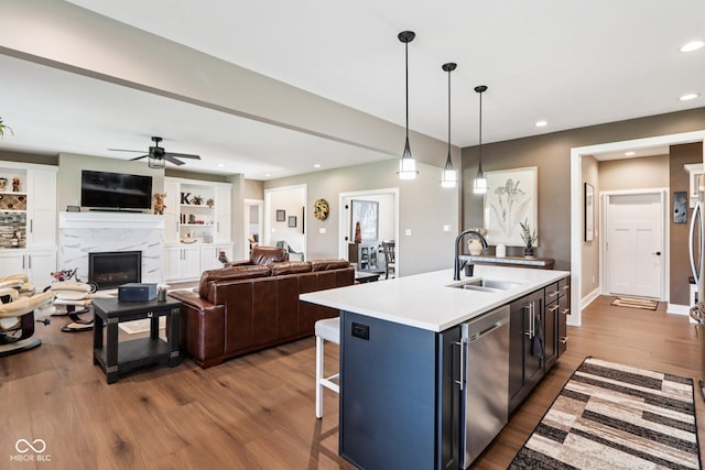 1295 Maclaren Ct, Franklin, IN 46131 - kitchen with a sink, a kitchen bar, light countertops, stainless steel dishwasher, and dark wood-style flooring