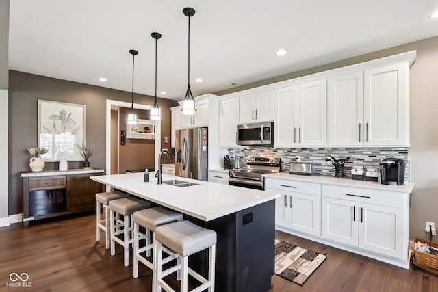 1295 Maclaren Ct, Franklin, IN 46131 - kitchen featuring stainless steel appliances, decorative backsplash, dark wood-style flooring, a center island with sink, and white cabinets