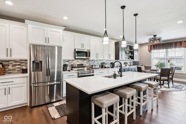 1295 Maclaren Ct, Franklin, IN 46131 - kitchen featuring stainless steel appliances, a sink, a breakfast bar, recessed lighting, and light countertops