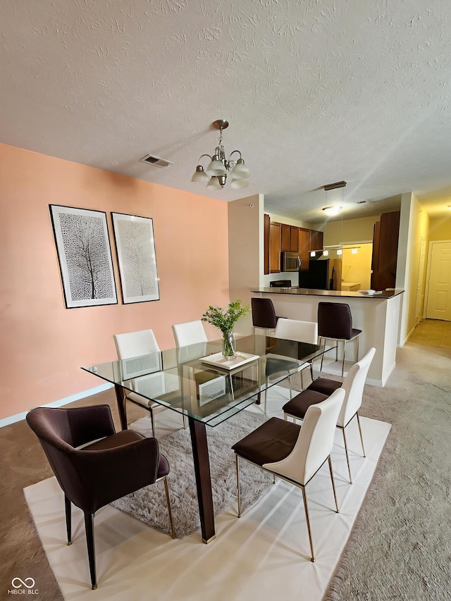 5011 Amber Creek Pl Unit 205, Indianapolis, IN 46237 - dining space featuring a chandelier, light carpet, a textured ceiling, and baseboards