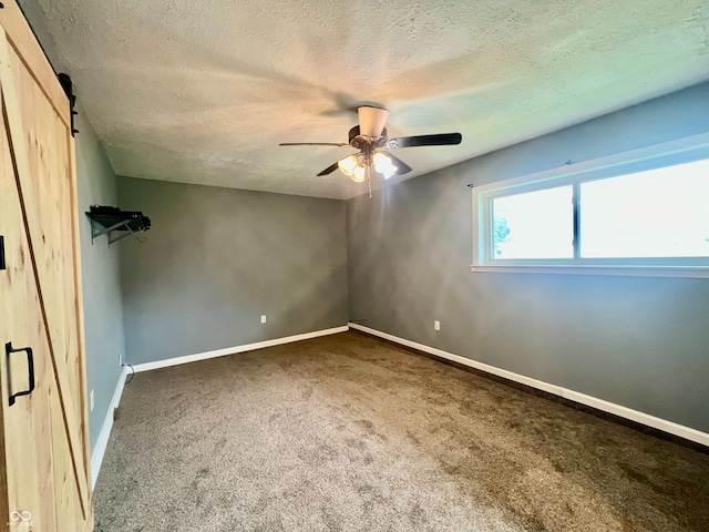 2833 Desoto Way, Columbus, IN 47203 - carpeted spare room with a textured ceiling, a barn door, ceiling fan, and baseboards