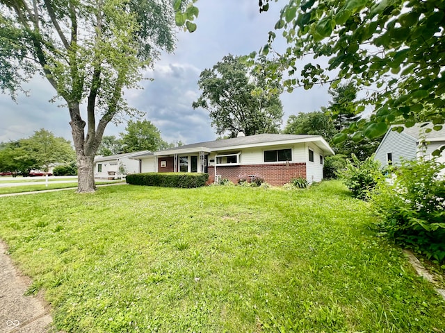 2833 Desoto Way, Columbus, IN 47203 - ranch-style house with brick siding, a garage, and a front lawn