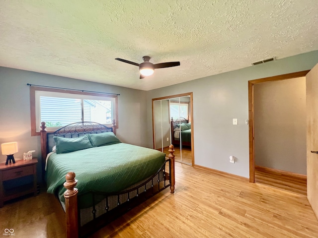 2833 Desoto Way, Columbus, IN 47203 - bedroom with a textured ceiling, light wood-type flooring, a closet, ceiling fan, and baseboards