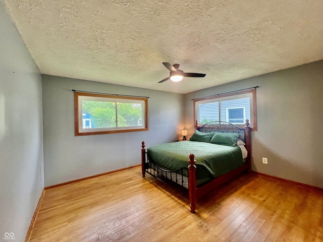 2833 Desoto Way, Columbus, IN 47203 - bedroom featuring light wood-type flooring, multiple windows, baseboards, and a textured ceiling
