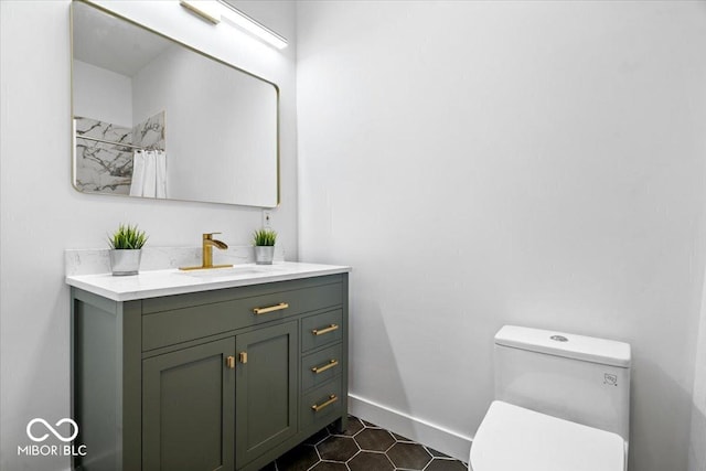1709 Fletcher Ave, Indianapolis, IN 46203 - bathroom featuring vanity, toilet, baseboards, tile patterned flooring, and curtained shower