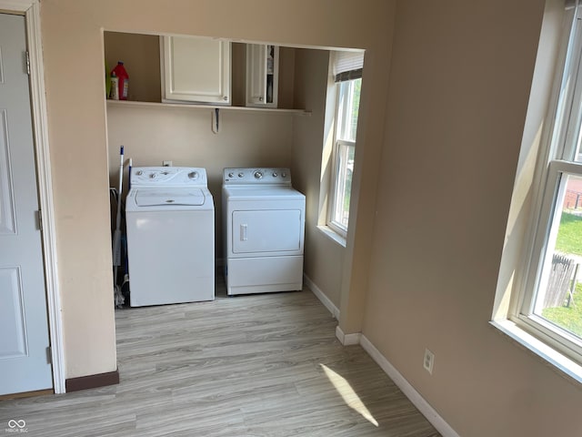 55 W Fall Creek Parkway S Drive, Indianapolis, IN 46208 - laundry area featuring separate washer and dryer, plenty of natural light, cabinet space, and light wood finished floors