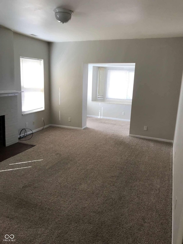 55 W Fall Creek Parkway S Drive, Indianapolis, IN 46208 - unfurnished living room featuring baseboards, carpet flooring, and a fireplace