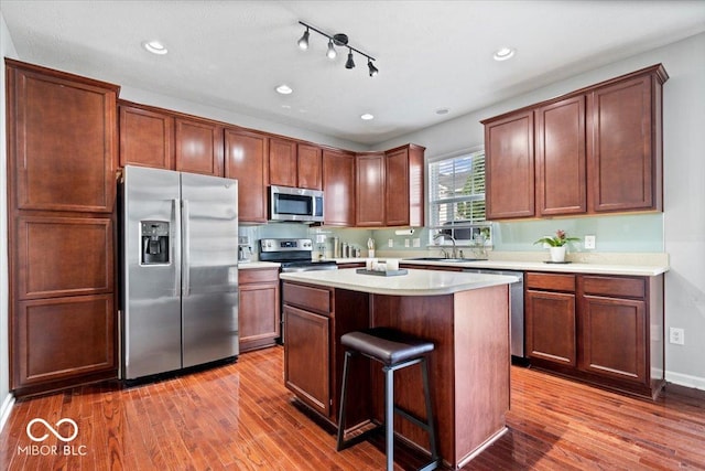 11509 Reagan Dr, Fishers, IN 46038 - kitchen with stainless steel appliances, a kitchen island, dark wood-style floors, light countertops, and recessed lighting