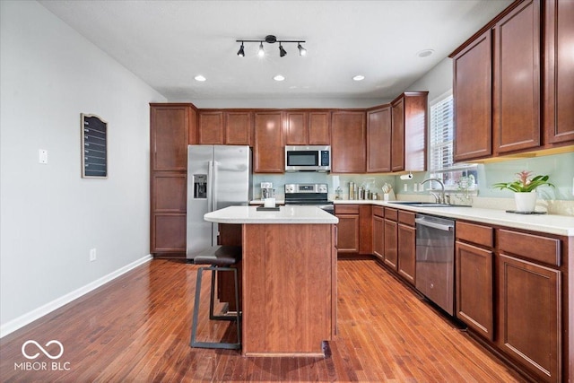 11509 Reagan Dr, Fishers, IN 46038 - kitchen with appliances with stainless steel finishes, a sink, baseboards, a breakfast bar area, and a center island