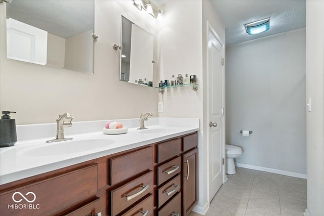 11509 Reagan Dr, Fishers, IN 46038 - full bathroom with double vanity, tile patterned flooring, toilet, baseboards, and a textured ceiling