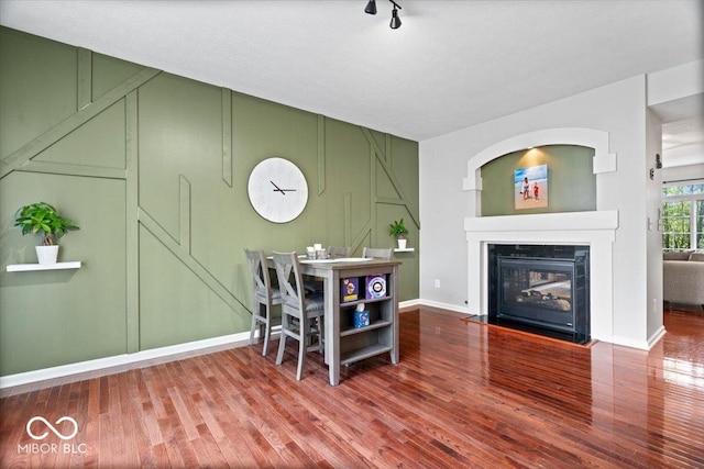 11509 Reagan Dr, Fishers, IN 46038 - dining area with a decorative wall, wood finished floors, a glass covered fireplace, and baseboards