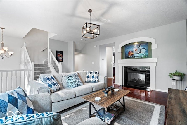 11509 Reagan Dr, Fishers, IN 46038 - living room featuring a chandelier, wood finished floors, a multi sided fireplace, stairway, and baseboards