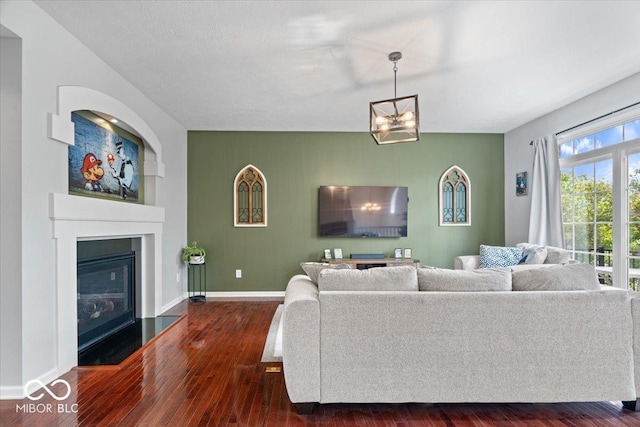 11509 Reagan Dr, Fishers, IN 46038 - living area featuring a glass covered fireplace, dark wood finished floors, and baseboards