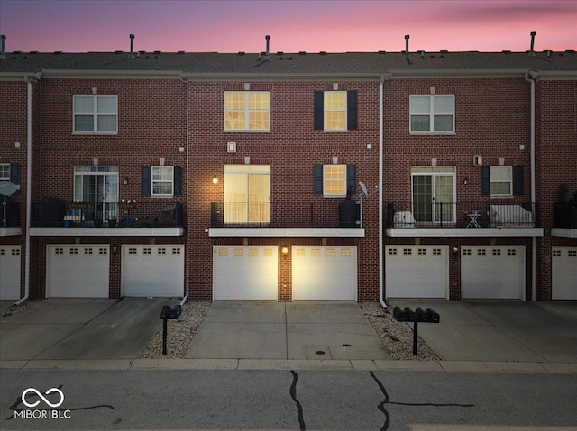 11509 Reagan Dr, Fishers, IN 46038 - back of property featuring an attached garage, driveway, and brick siding