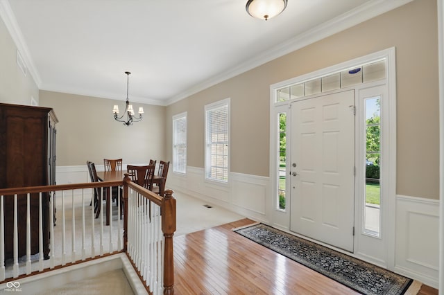 16802 Oak Manor Dr, Westfield, IN 46074 - foyer entrance featuring hardwood / wood-style flooring, a wainscoted wall, a chandelier, crown molding, and a decorative wall