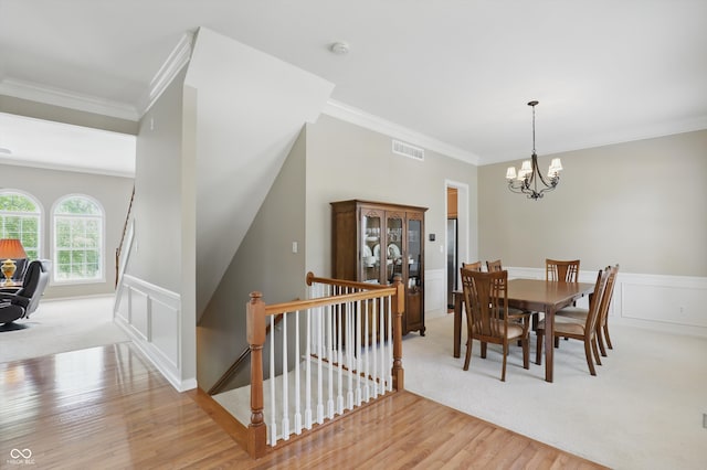 16802 Oak Manor Dr, Westfield, IN 46074 - dining room with crown molding, light wood-style floors, a chandelier, light colored carpet, and wainscoting
