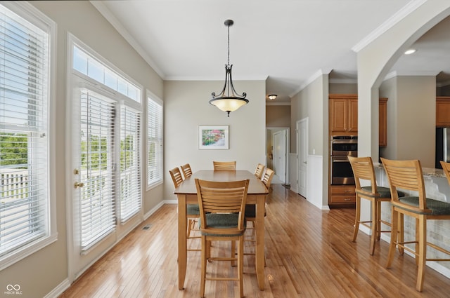 16802 Oak Manor Dr, Westfield, IN 46074 - dining area with light wood-style flooring, arched walkways, ornamental molding, and baseboards