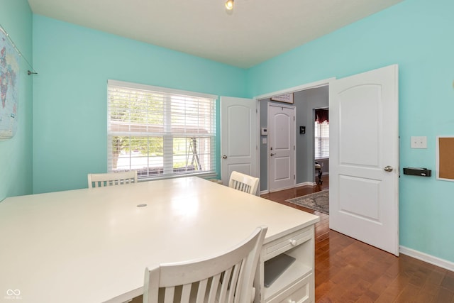 1696 Woodfield Dr, Greenwood, IN 46143 - kitchen featuring dark wood-style flooring, baseboards, a kitchen breakfast bar, and light countertops
