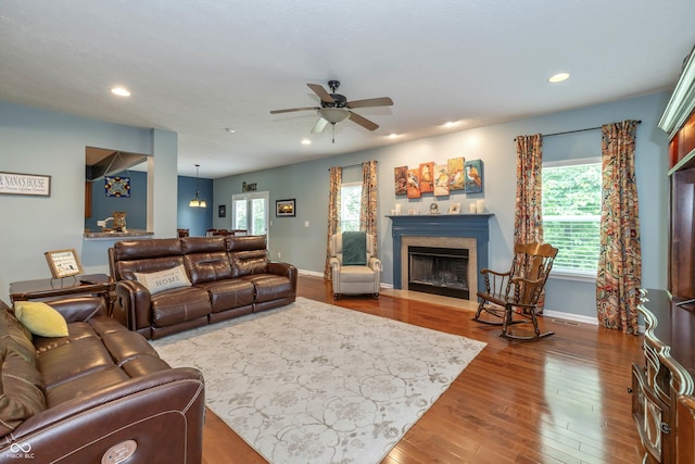 1696 Woodfield Dr, Greenwood, IN 46143 - living area featuring a fireplace with flush hearth, plenty of natural light, wood finished floors, and recessed lighting