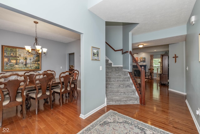 1696 Woodfield Dr, Greenwood, IN 46143 - dining area with stairway, wood finished floors, a chandelier, and baseboards