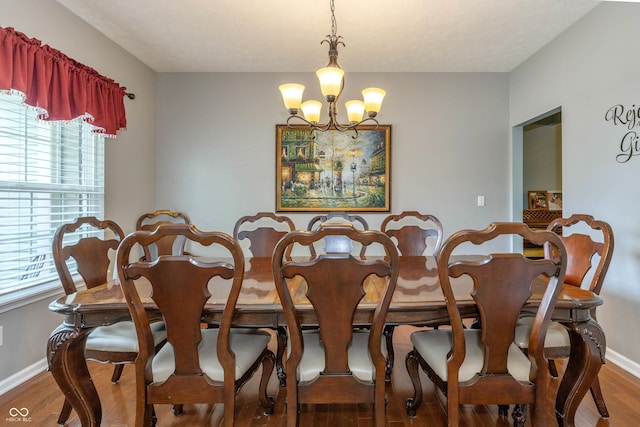 1696 Woodfield Dr, Greenwood, IN 46143 - dining area with a chandelier, wood finished floors, and baseboards