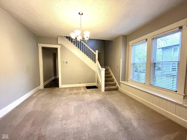 38 N Irvington Ave, Indianapolis, IN 46219 - empty room with a textured ceiling, a chandelier, stairs, and carpet floors