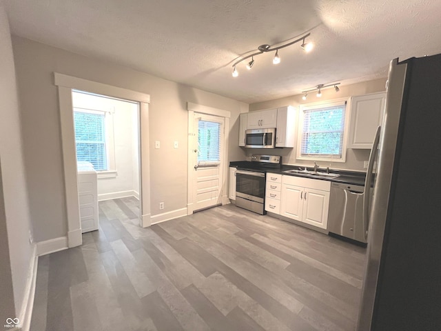 38 N Irvington Ave, Indianapolis, IN 46219 - kitchen with stainless steel appliances, dark countertops, white cabinets, light wood finished floors, and a textured ceiling