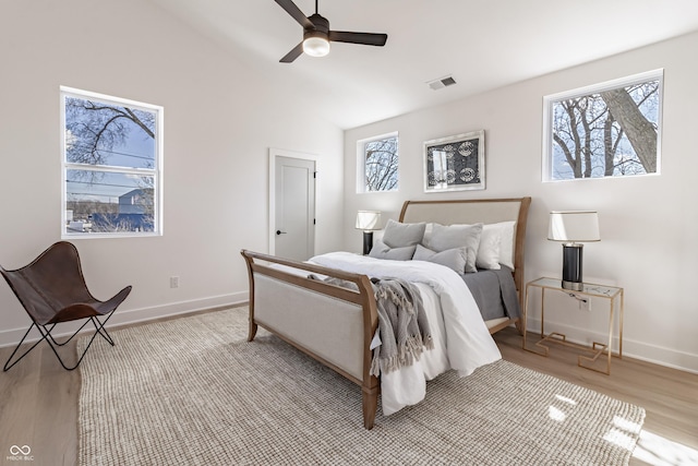 2051 Columbia Ave, Indianapolis, IN 46202 - bedroom featuring light wood-style flooring, multiple windows, baseboards, and lofted ceiling