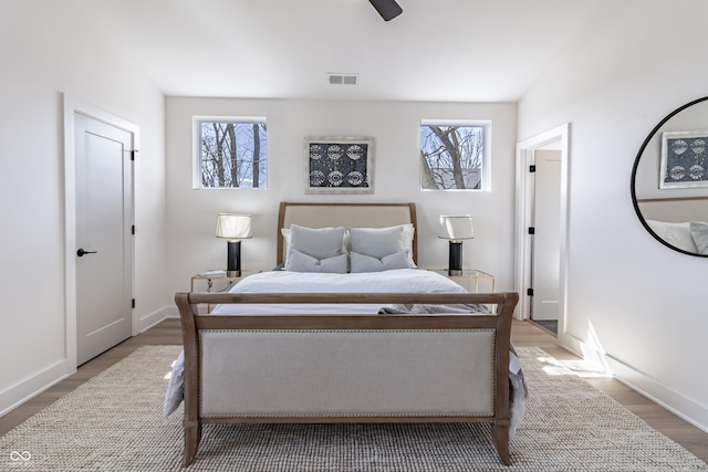 2051 Columbia Ave, Indianapolis, IN 46202 - bedroom featuring multiple windows, wood finished floors, baseboards, and ceiling fan