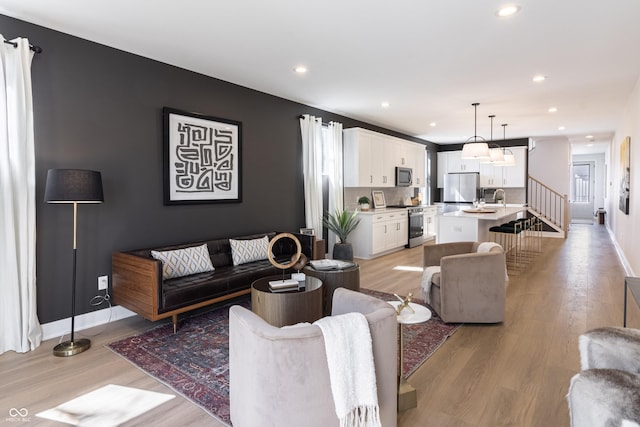2051 Columbia Ave, Indianapolis, IN 46202 - living room featuring light wood finished floors, recessed lighting, baseboards, and stairs
