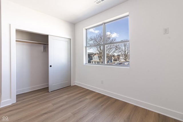 2053 Columbia Ave, Indianapolis, IN 46202 - unfurnished bedroom featuring light wood-style floors, baseboards, and a closet