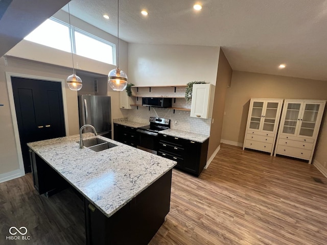 6805 Twin Brooks Dr, Indianapolis, IN 46227 - kitchen featuring stainless steel appliances, backsplash, wood finished floors, a center island with sink, and dark cabinetry