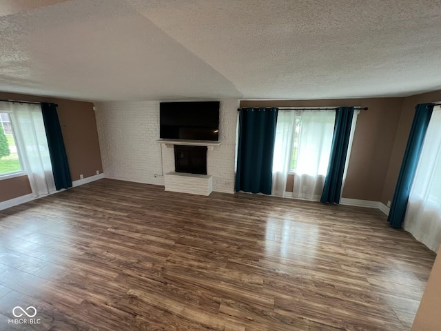 6805 Twin Brooks Dr, Indianapolis, IN 46227 - unfurnished living room featuring a textured ceiling, plenty of natural light, a fireplace, and wood finished floors
