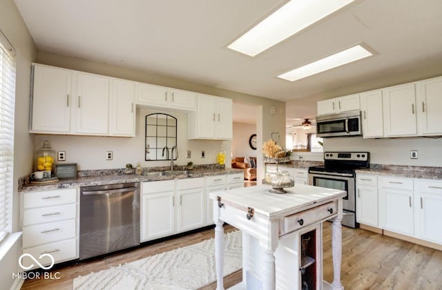 10197 Apple Blossom Cir, Fishers, IN 46038 - kitchen with stainless steel appliances, a sink, white cabinets, light wood-style floors, and light stone counters