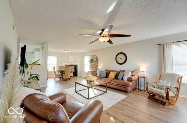 10197 Apple Blossom Cir, Fishers, IN 46038 - living area featuring light wood-style floors, a ceiling fan, a textured ceiling, and baseboards