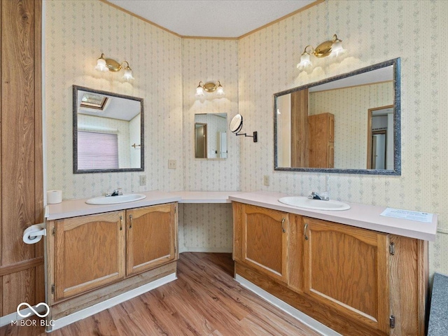 1447 NE Kutenai Trl, Greensburg, IN 47240 - bathroom featuring wood finished floors, ornamental molding, and two vanities